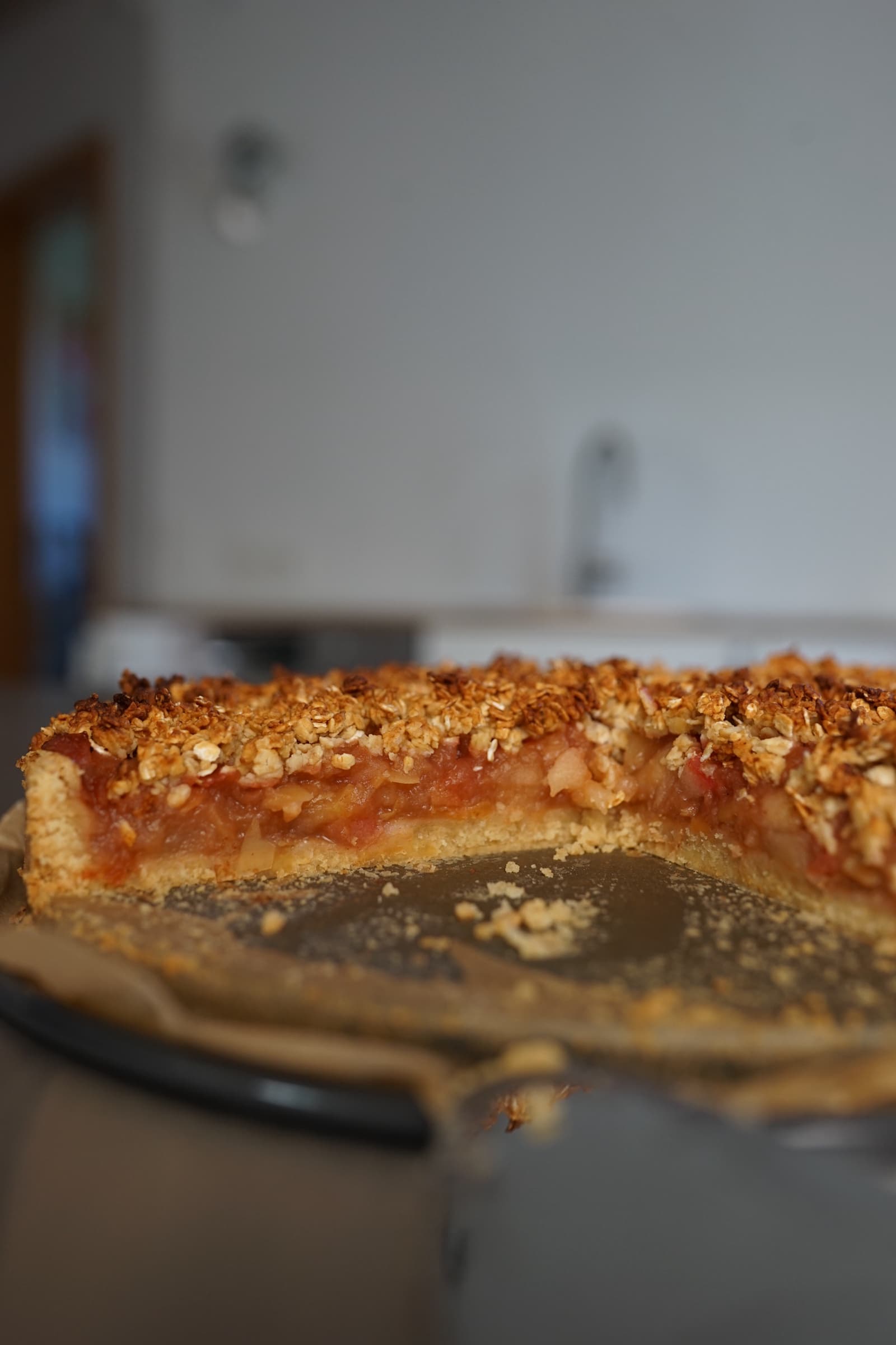 Angeschnittener Apfelkuchen mit saftiger Apfelfüllung und knusprigen Haferstreuseln