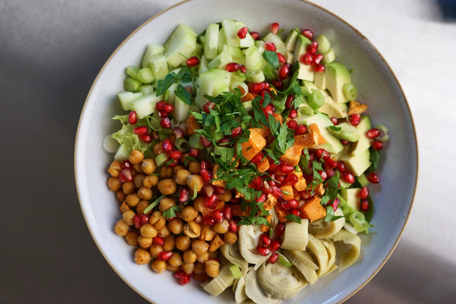Crispy Sweet Potato Ranch Bowl mit Kichererbsen, Artischocken und Granatapfelkernen von oben