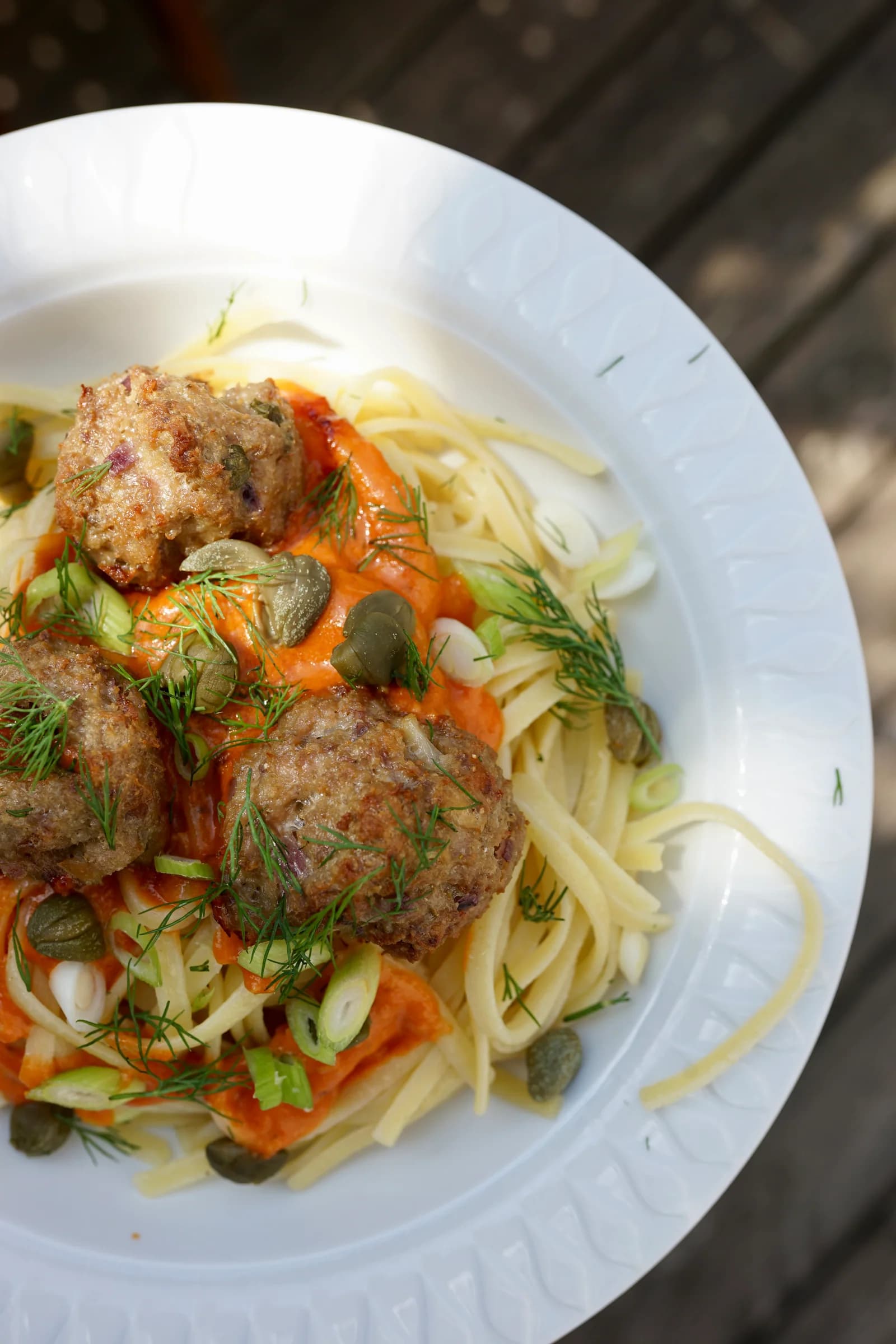 Nahaufnahme von Spaghetti mit gebackenen Ricotta-Meatballs und roter Pesto-Soße
