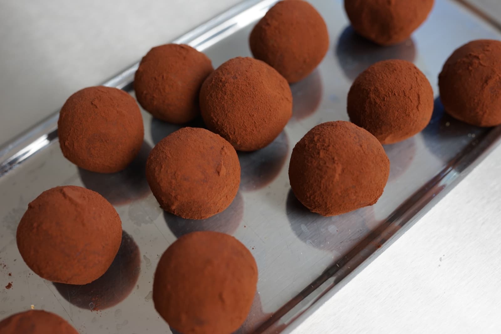 Tiramisu-Balls mit Kakaopulver auf einem silbernen Tablett