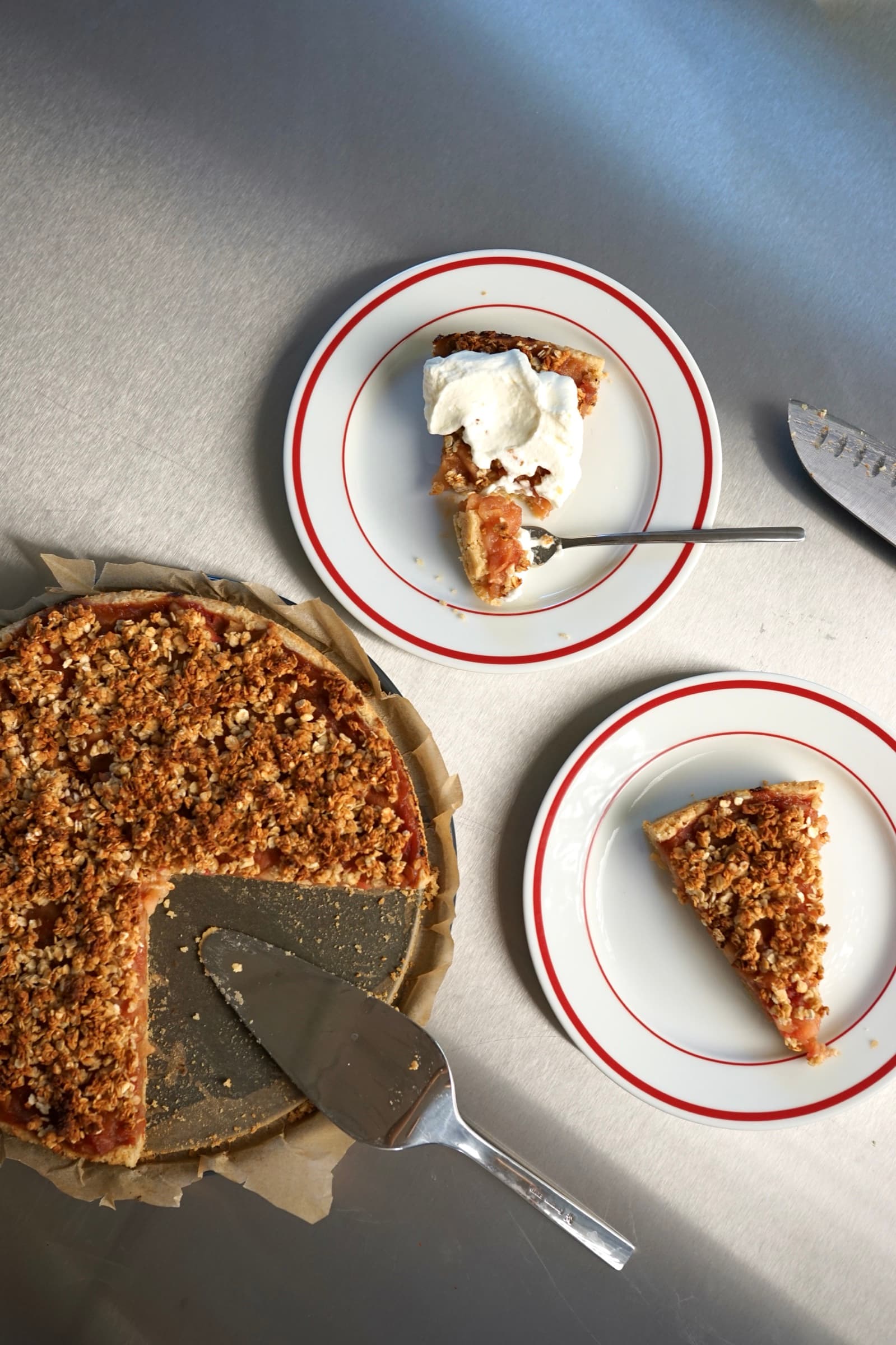 Apfelkuchen mit Haferstreuseln und Vanillesahne auf einer gedeckten Tafel