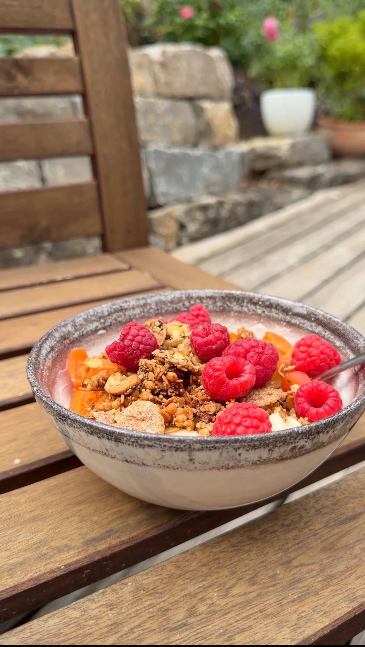 Frühstücksbowl mit knusprigem Granola und frischen Himbeeren